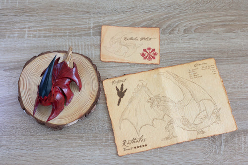 Rathalos Plate replica and parchment documents in front of a wood background